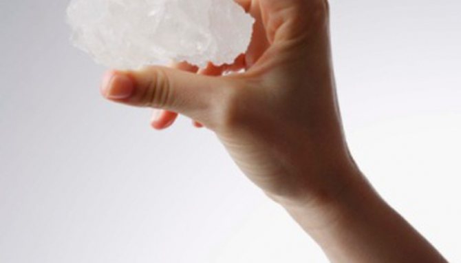 солевой кристалл в руке